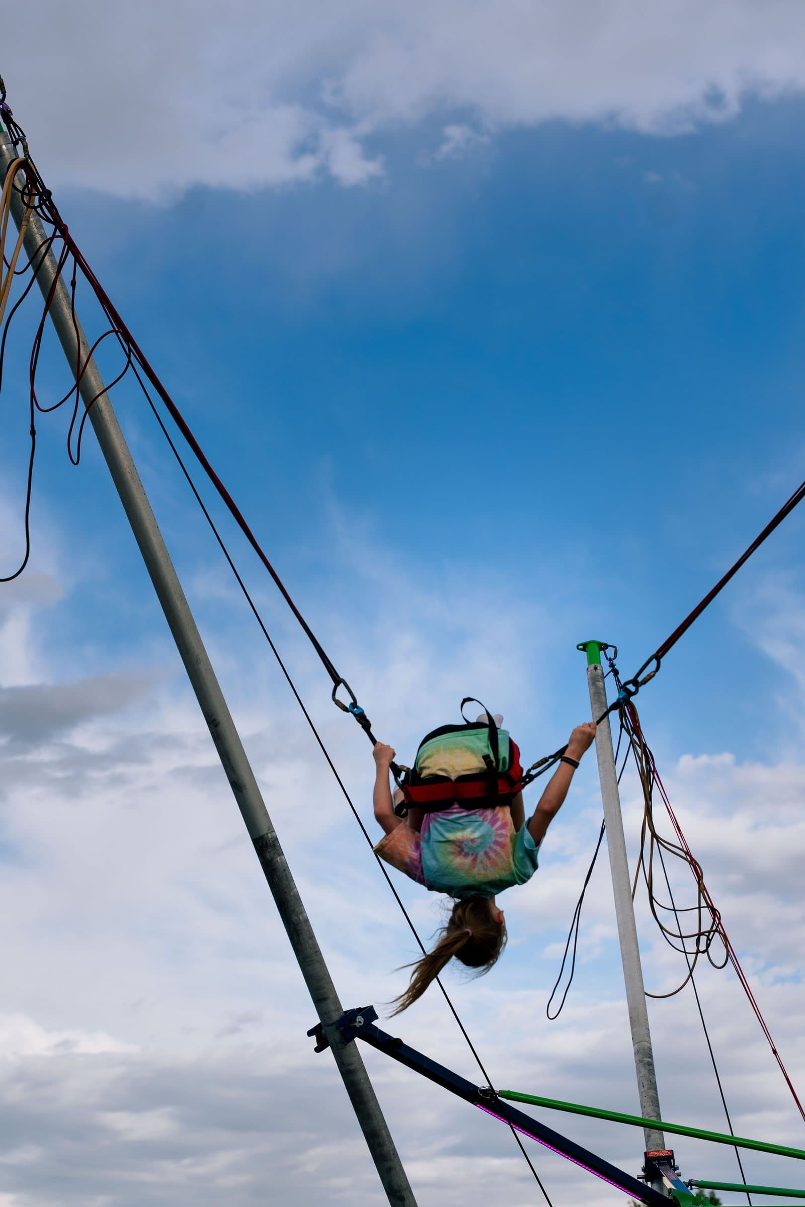 Bungee jumper high against a blue sky at a Castle Pines community festival