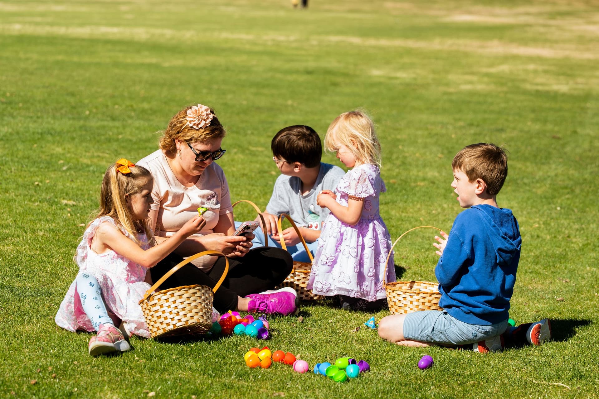 Siblings sorting their Easter eggs on the lawn