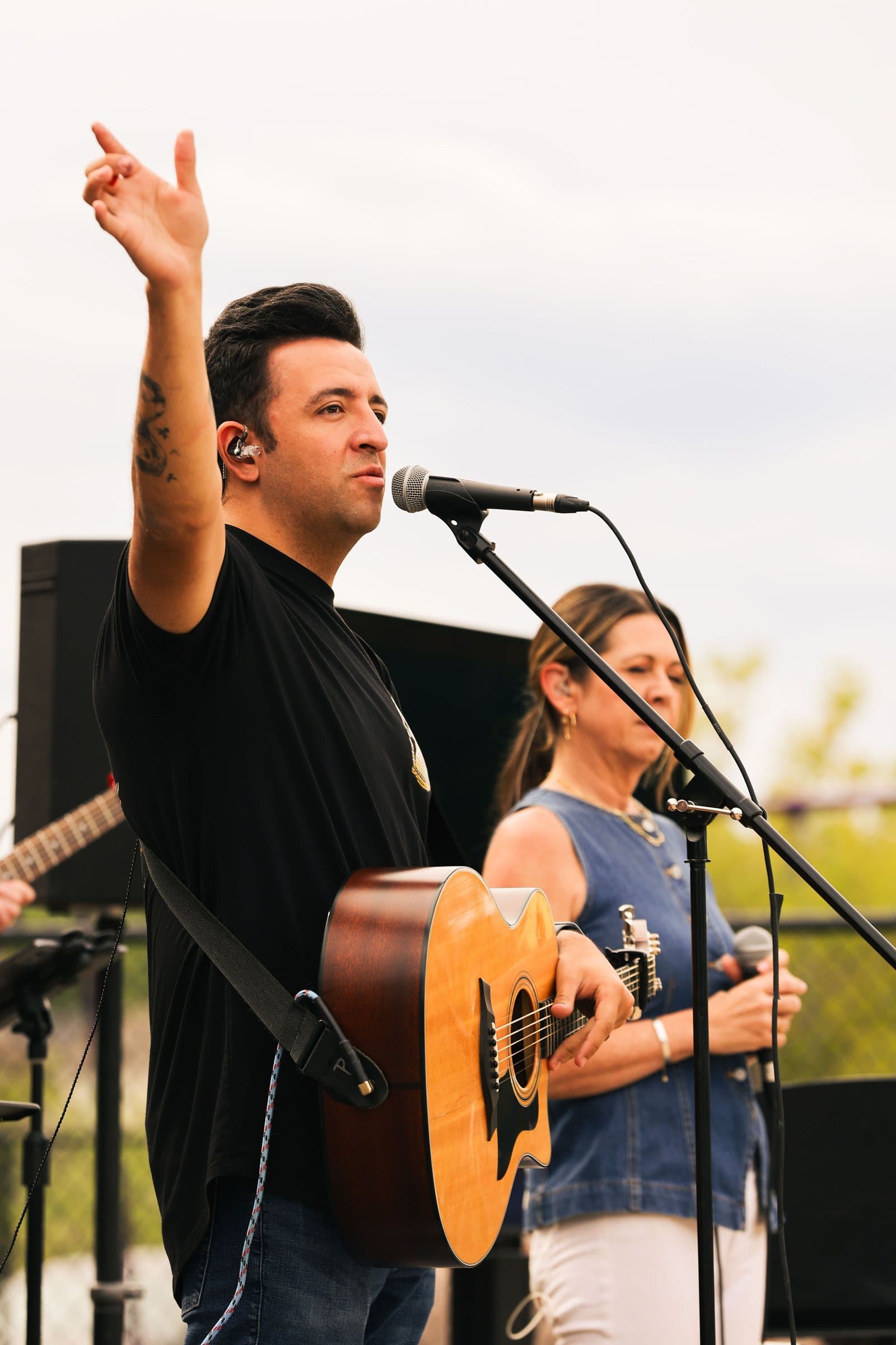 Guitarist with hand raised in worship at Mountain View church's outdoor service