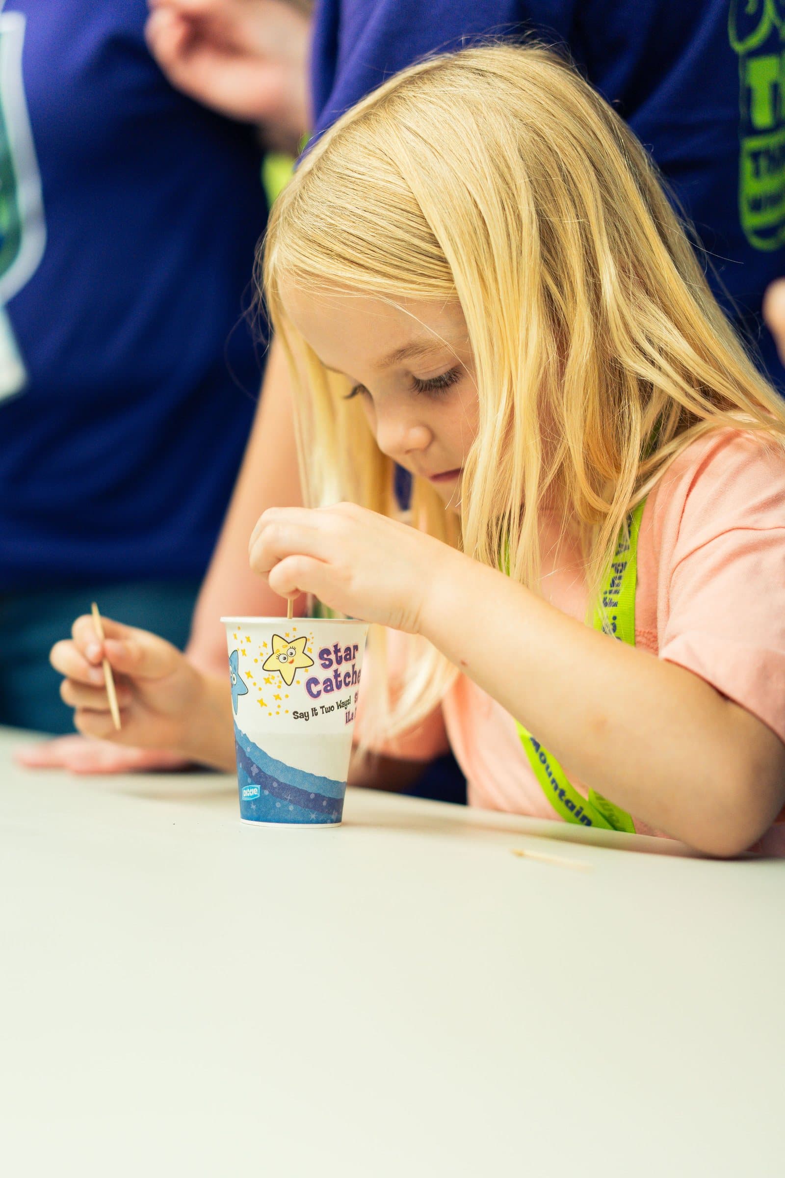 Girl focused on a science experiment at VBS 2026