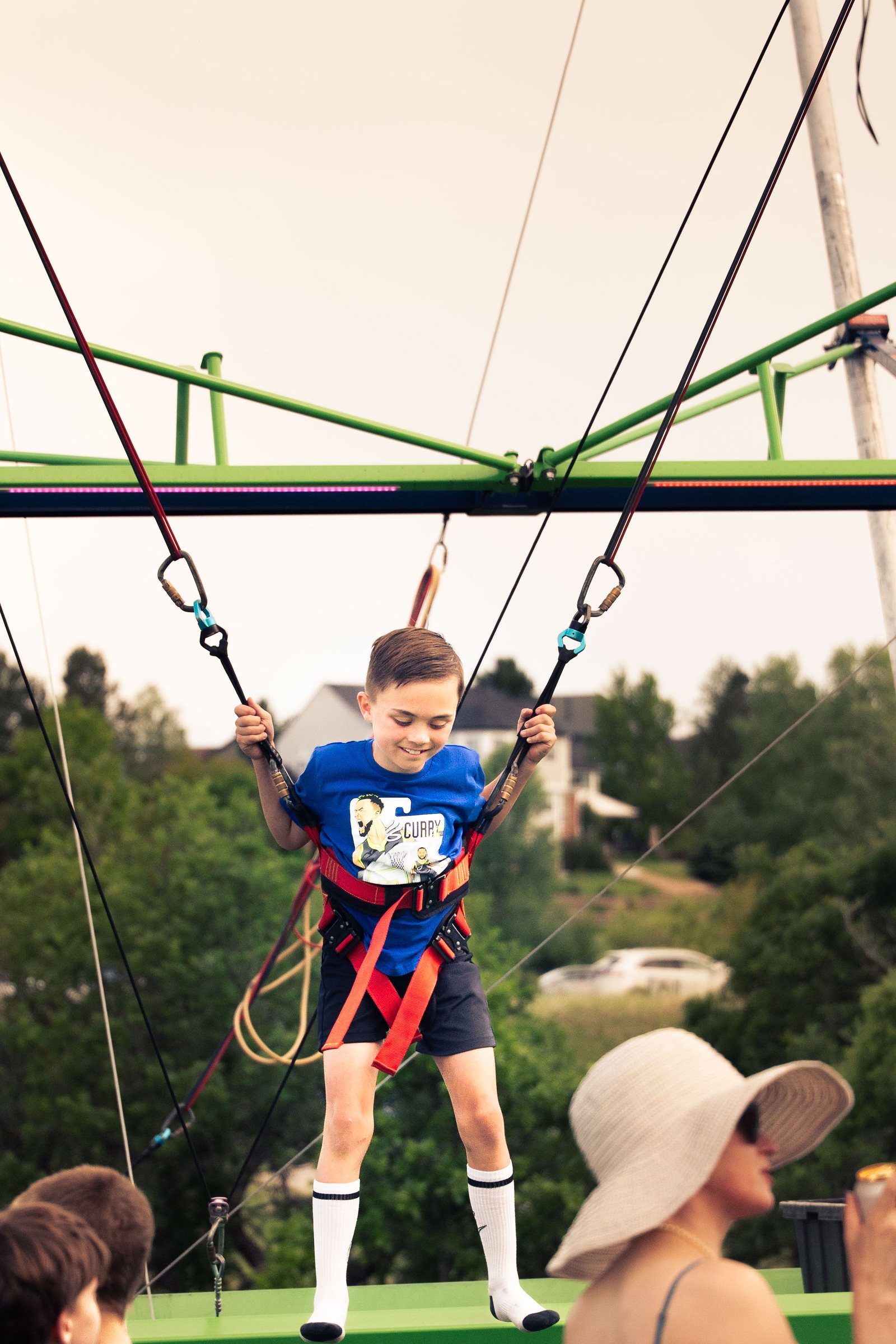 Kid soaring on a bungee trampoline at the Castle Pines festival, Colorado event photography