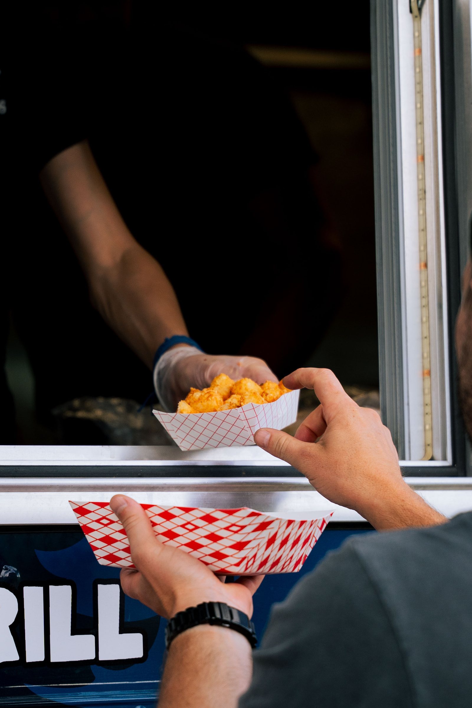 Food truck handing an order of fries to a customer, Colorado event photography