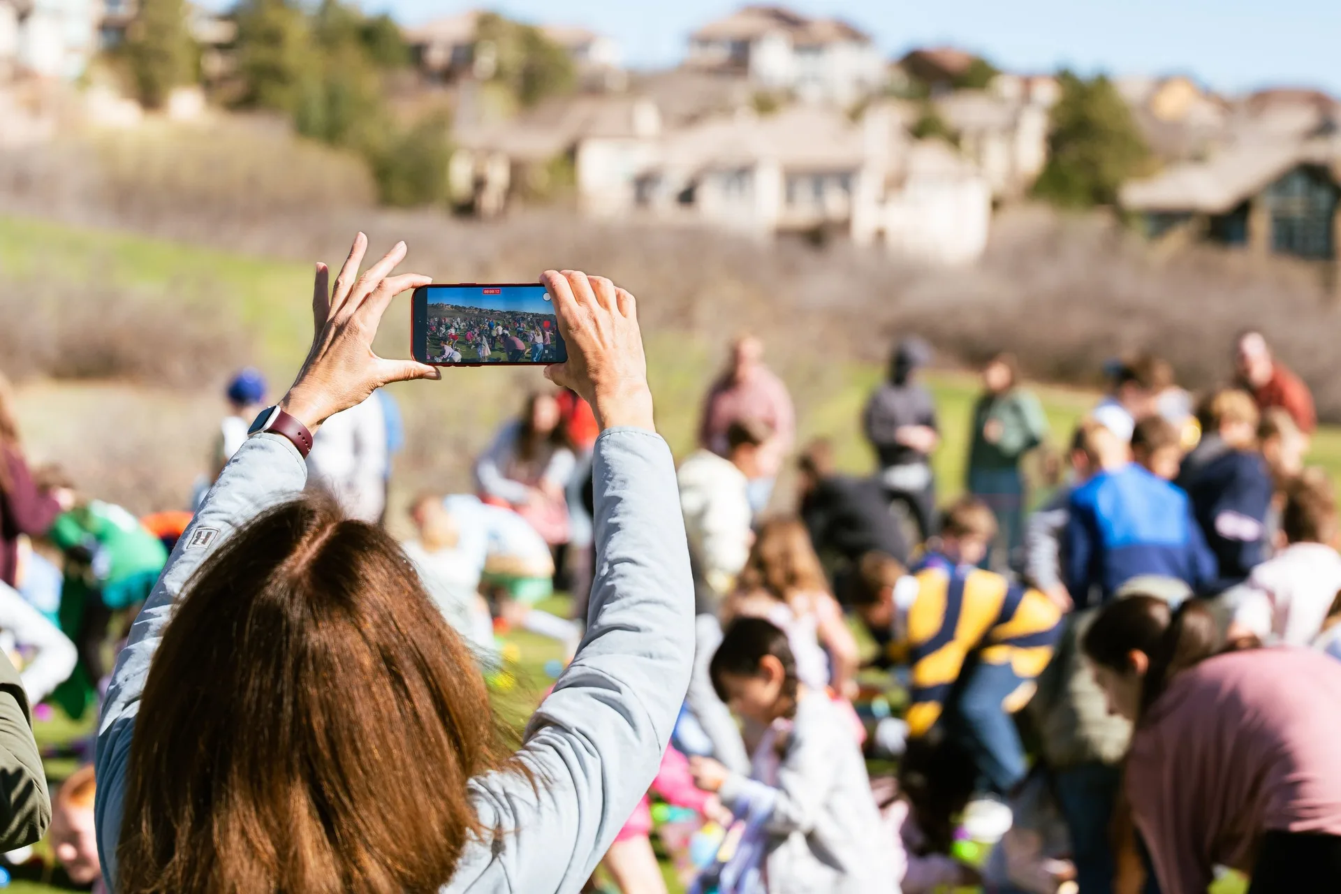Parents taking photos of kids at the community Easter egg hunt