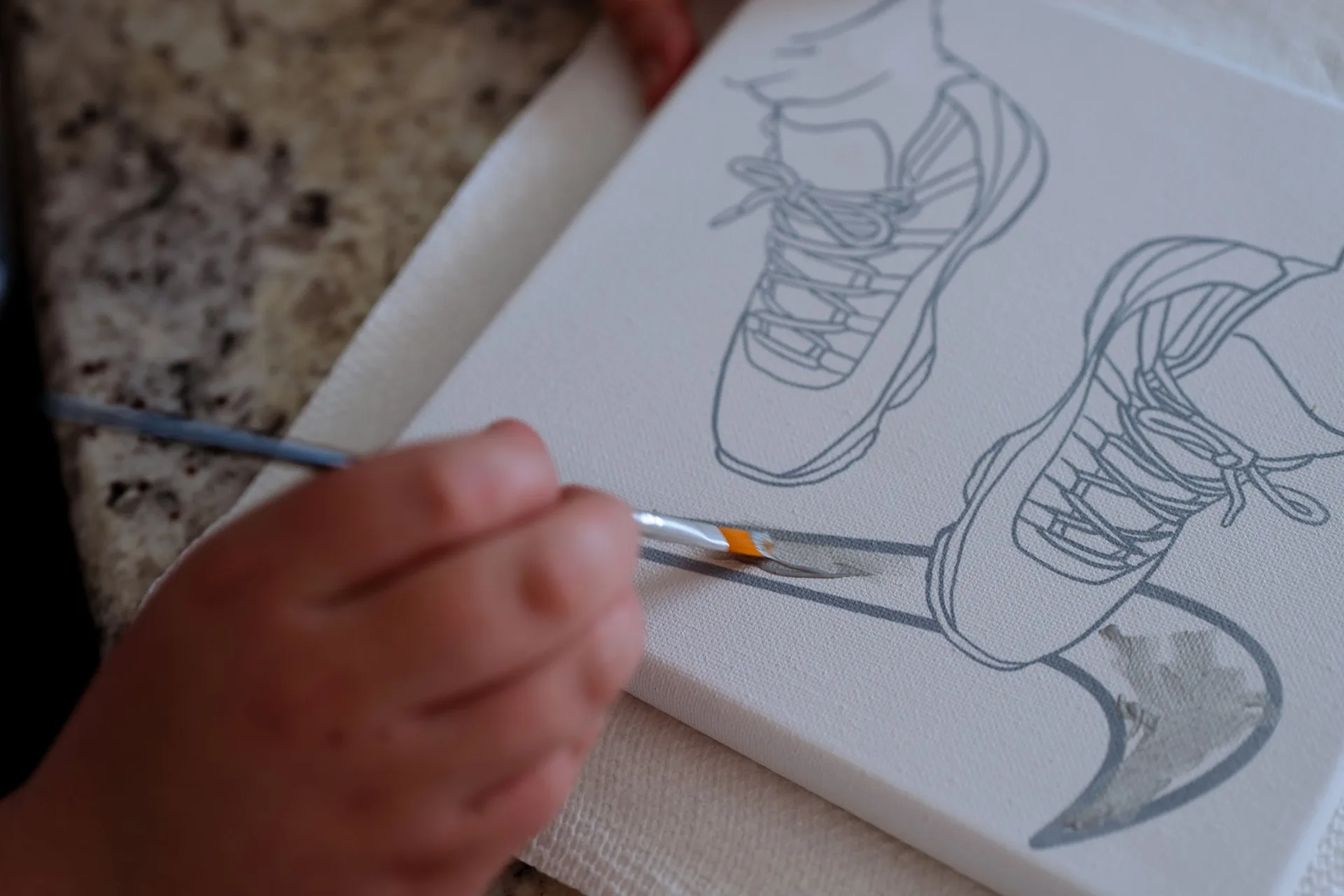Hands painting a sneaker design on canvas, Free Your Mind Creative Space social content