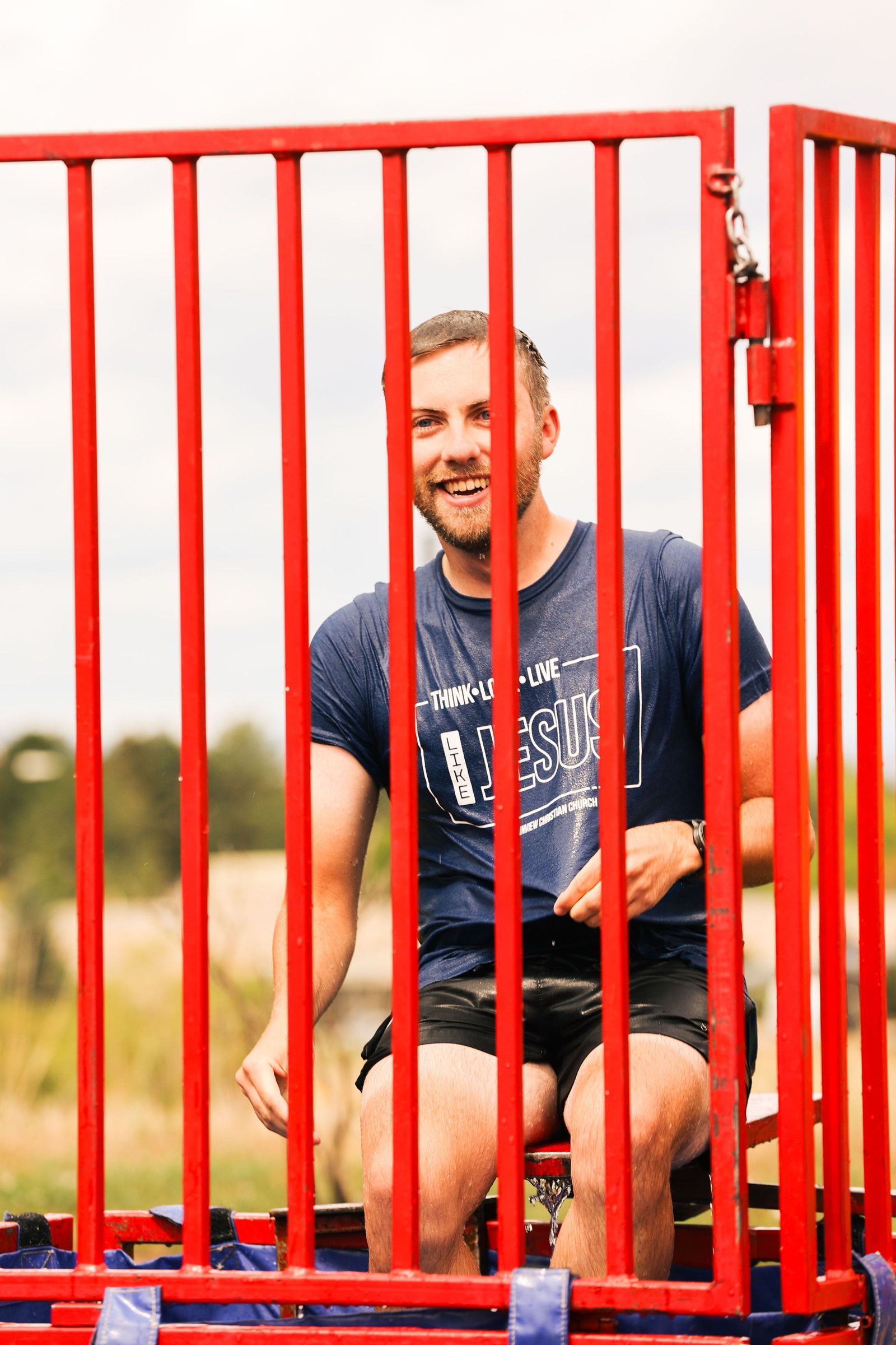 Smiling volunteer in a dunk tank at a church community picnic
