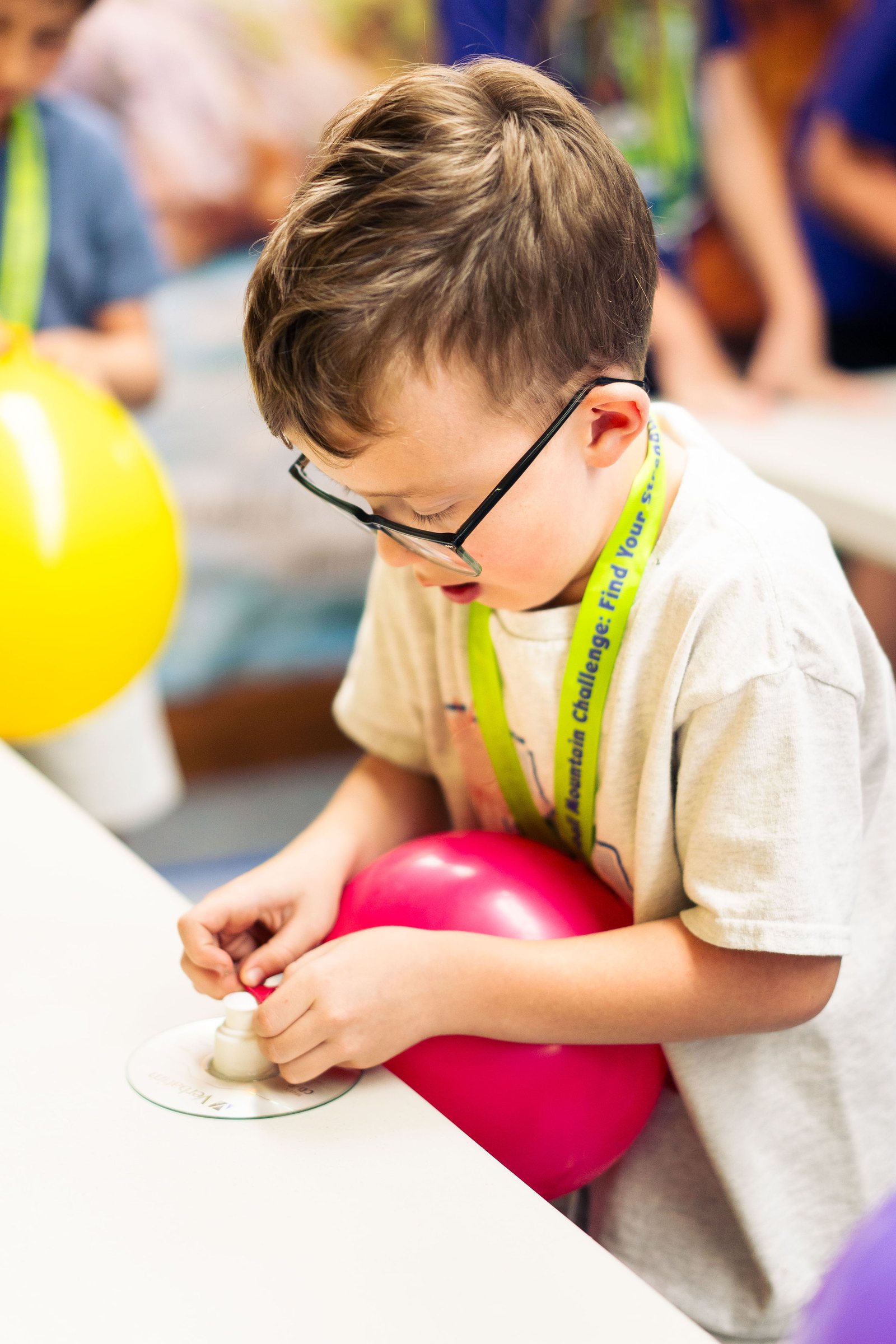 Boy inflating a balloon during a Vacation Bible School science activity